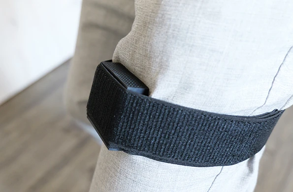 BioMoov de Mazet Santé fixé à la jambe d'un patient avec une sangle pour capter les mouvements, inclus avec l'appareil